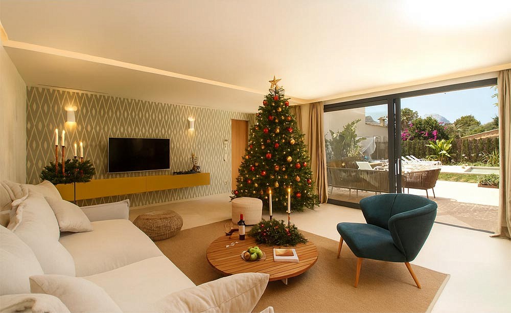 Wohnzimmer der Villa Maronja mit Weihnachtsbaum, Kerzen und Blick auf Terrasse und Pool